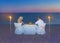 Loving couple at romantic dinner with torch flares, candles and