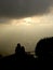 A loving couple silhouette watching sun beams over the city