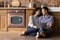 Loving couple sitting on kitchen floor planning wedding using laptop