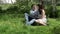 Loving couple sitting in the park on the grass in spring