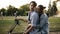 Loving couple spending a relaxing moment together sitting on minibike in a close embrace. Happy contented smiles, tender