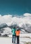 Loving couple standing and looking on beautiful snowy mountains peaks. Vertical panoramic view. Back view