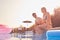 Loving Couple On Summer Vacation Sitting On Edge Of Swimming Pool