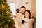 Loving couple taking selfie near the Christmas decorated fireplace