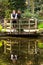 Loving couple in Victorian fashion near lake with reflections in park