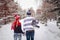 Loving couple walking on a date in a winter Park. On the back of a guy hangs a pair of skates