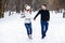 Loving couple walking on a date in a winter Park. On the girl`s back hanging a pair of skates.