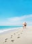 Loving couple walking with footprints at sea