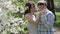 Loving couple walking in a park near a blossoming tree