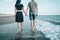 Loving couple walking on sand coast.