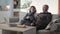 loving elderly couple enjoy time together and eat sandwich while sitting on sofa in living room