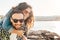 Loving embraced couple having fun on beach vacation - man giving piggyback ride to woman - boyfriend and girlfriend together in a