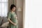 Loving expectant mother stand by window caressing baby bump