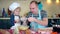 Loving father with her excited cute daughter girl sifting flour in kitchen