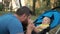 Loving father kissing feet of his baby son in park