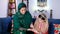 A loving girl child spending quality time with her caring mother while decorating her hand with Henna