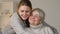 Loving granddaughter hugging happy disabled woman in wheelchair, family values