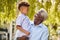 Loving Grandfather Holding Grandson In Arms In Garden At Home