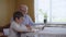 Loving grandfather shows his beloved little grandson a family photo album sitting at a table