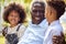 Loving Grandfather Talking With Grandchildren In Garden At Home