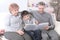 Loving grandparents with grandchild sitting on sofa