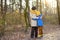 Loving grandson tenderly embracing his joyful elderly grandmother during walking in autumn park. Friendship granny and grandchild