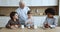 Loving great-grandfather treats little grandsons with milk and cookies