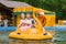 Loving happy couple riding a jet ski in the form of flamingos in the amusement Park