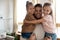 Loving happy young daddy holding two kids daughters, portrait