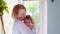 A loving happy young mother hugs a nursing son in the nursery. Beautiful light. The concept of love, family and