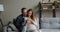 Loving husband hugs pregnant wife using smartphone purchasing on internet