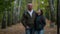 Loving husband and wife are embracing and walking in picturesque alley in autumn park, medium portrait shot