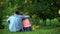 Loving male and female hugging sitting on grass in park, couple togetherness