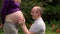 Loving man playing with pregnant woman belly in park