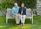 Loving married senior couple sitting together on a wooden bench in the Garden of the Villa Cipressi in Varenna.