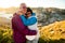 Loving mature couple traveling, standing on the top of rock, exploring