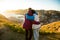 Loving mature couple traveling, standing on the top of rock, exploring