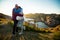 Loving mature couple traveling, standing on the top of rock, exploring