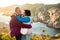 Loving mature couple traveling, standing on the top of rock, exploring