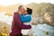 Loving mature couple traveling, standing on the top of rock, exploring