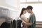 Loving Mixed Couple Hugging Standing Near Laundromat Washing Machines Indoor