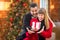 Loving Mixed Race Couple Sharing Christmas In Front of Decorated Tree.