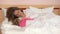 Loving mom caress her child girl lying in bed to make fall asleep