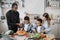 Loving mom, dad and small sons kids cooking dinner together.