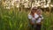Loving mom and son hugging and playing with a soccer ball in a field with spikelets in beautiful sunset light in white t