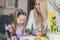 Loving mother and her daughter painting easter eggs