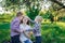 Loving mother playing with children. Two sons stroking mom`s head. Picnic with family in nature