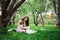 Loving mother reading book to toddler son outdoor on picnic in spring or summer park