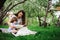 Loving mother reading book to toddler son outdoor on picnic in spring or summer park. Happy family and mothers day