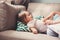 Loving mother tickling her little girl on the sofa